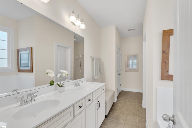 full bathroom featuring a sink, baseboards, double vanity, and tile patterned flooring