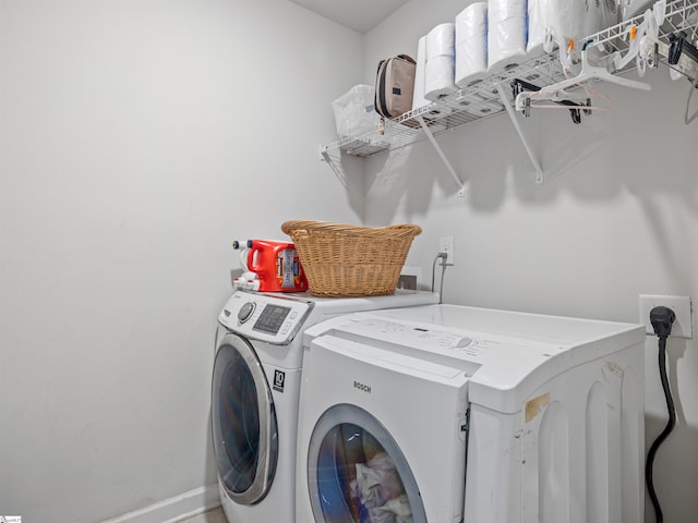 laundry area with laundry area, washer and clothes dryer, and baseboards