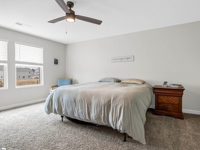 carpeted bedroom with a ceiling fan, visible vents, and baseboards