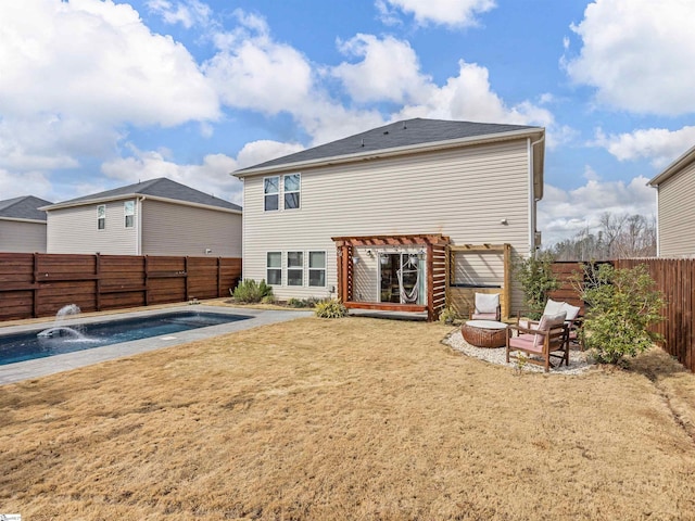 back of house with an outdoor fire pit, a lawn, a fenced backyard, and a fenced in pool