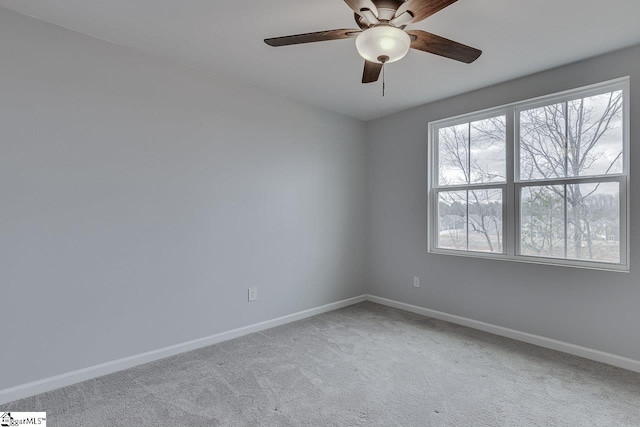 carpeted empty room with ceiling fan and baseboards