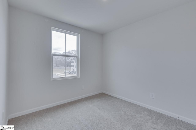 unfurnished room with carpet and baseboards