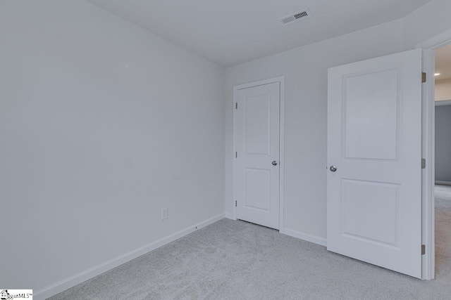 unfurnished bedroom featuring carpet floors, visible vents, and baseboards