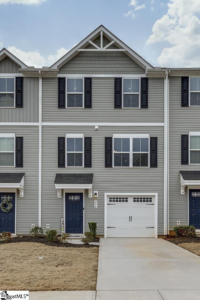 multi unit property with concrete driveway and an attached garage