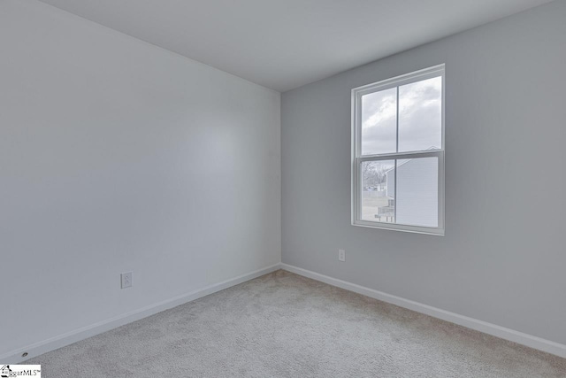 spare room featuring carpet and baseboards