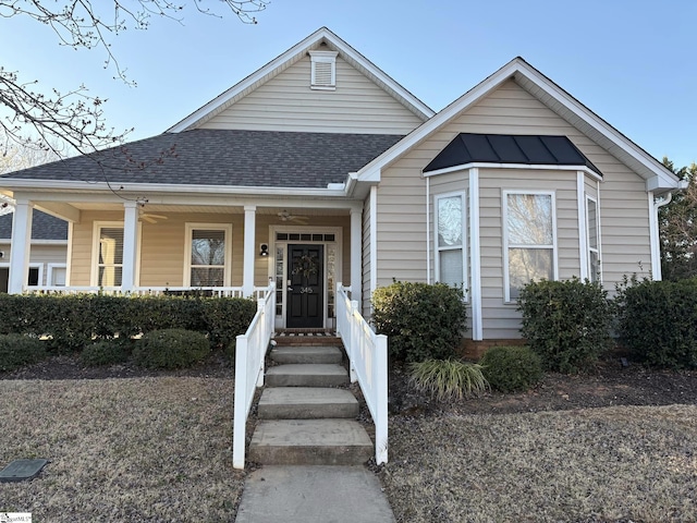 bungalow-style home with ceiling fan, a porch, and roof with shingles