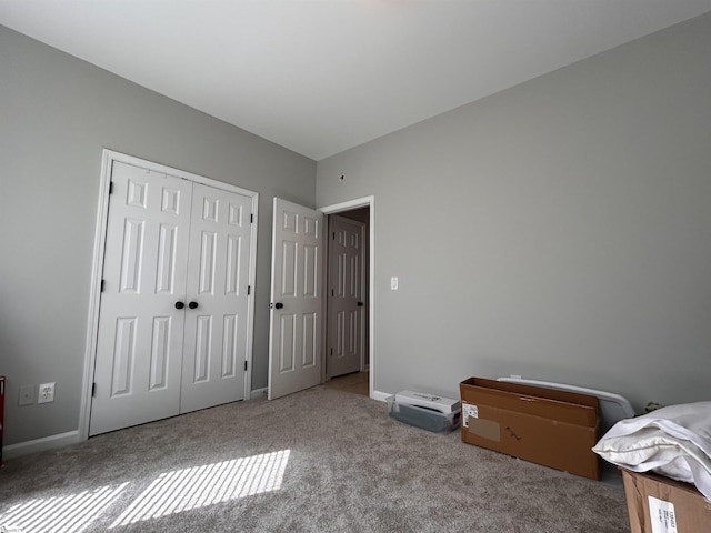 bedroom with a closet, carpet, and baseboards