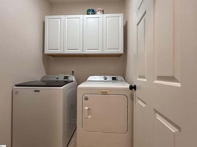 clothes washing area featuring cabinet space and separate washer and dryer