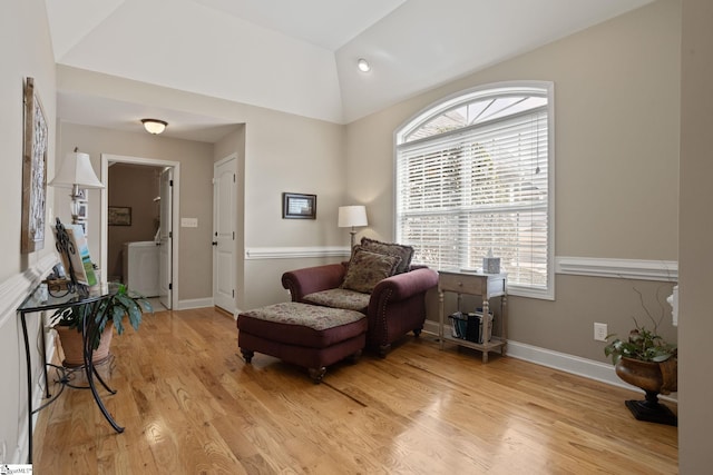 living area with lofted ceiling, light wood-style flooring, and baseboards