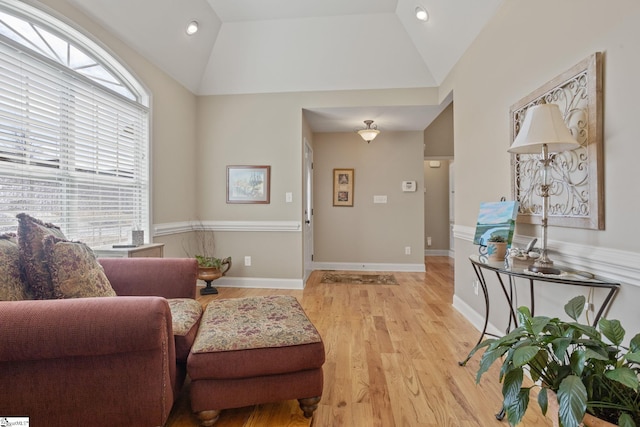 interior space with light wood-style flooring, baseboards, and vaulted ceiling