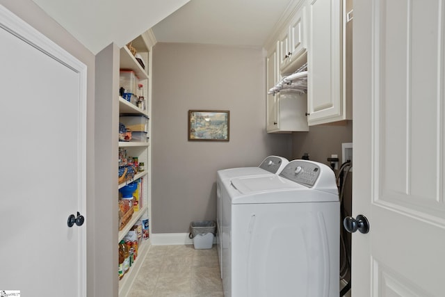 washroom featuring baseboards, cabinet space, and washer and dryer