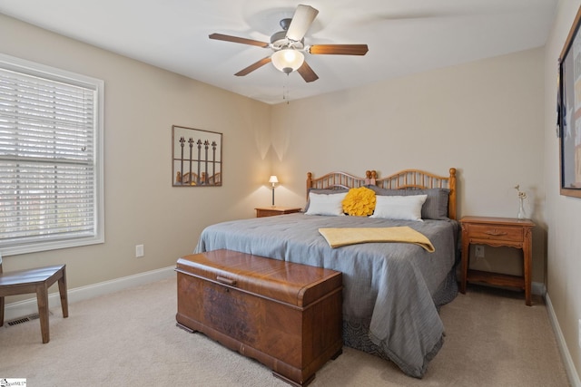 bedroom with light carpet, a ceiling fan, and baseboards