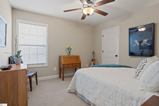 bedroom featuring baseboards, a ceiling fan, and light colored carpet