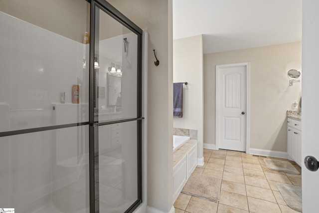 bathroom featuring a garden tub, vanity, baseboards, tile patterned floors, and an enclosed shower