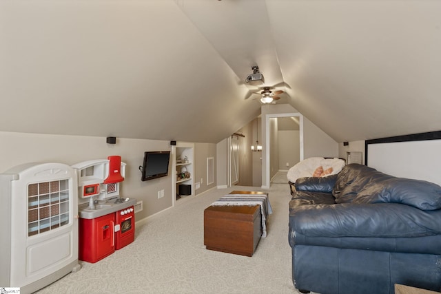 carpeted living area with vaulted ceiling, built in shelves, visible vents, and baseboards