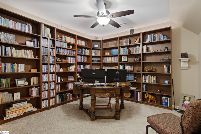 carpeted home office featuring a ceiling fan and bookshelves