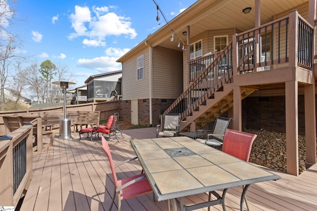 wooden terrace featuring stairway and outdoor dining area