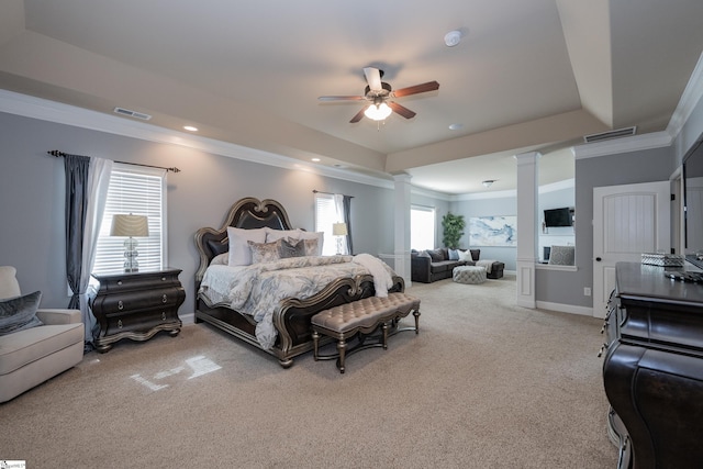 bedroom with light carpet, visible vents, ornamental molding, a tray ceiling, and ornate columns