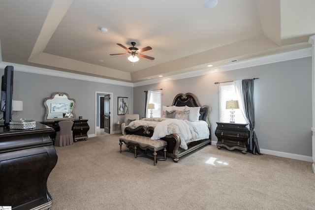 carpeted bedroom with a tray ceiling, recessed lighting, ornamental molding, a ceiling fan, and baseboards