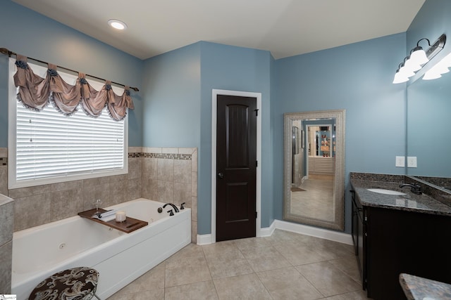 full bathroom featuring a whirlpool tub, tile patterned flooring, baseboards, and vanity