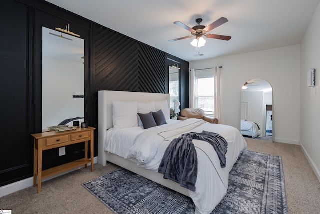 bedroom with arched walkways, light carpet, visible vents, a ceiling fan, and baseboards