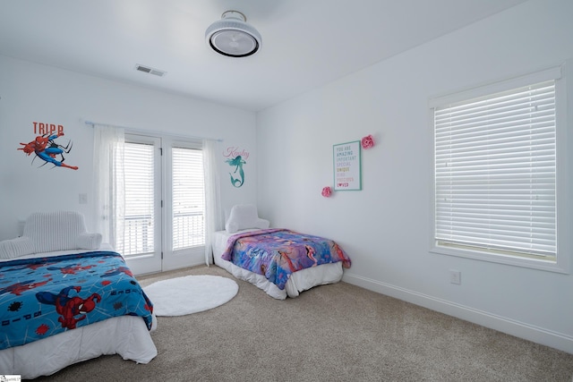 carpeted bedroom with access to exterior and baseboards