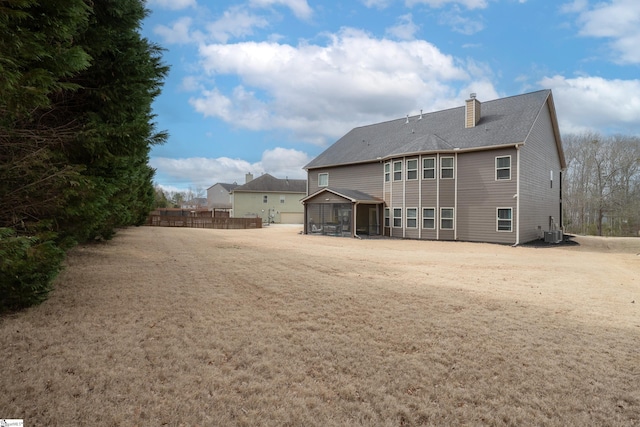 back of property featuring a chimney, fence, and central AC unit