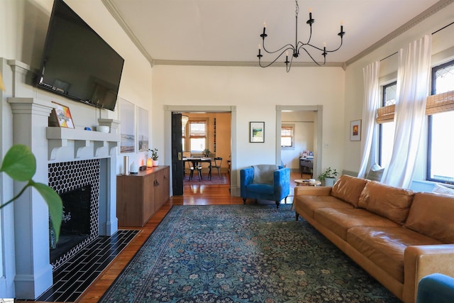 living area with ornamental molding, a fireplace, and wood finished floors