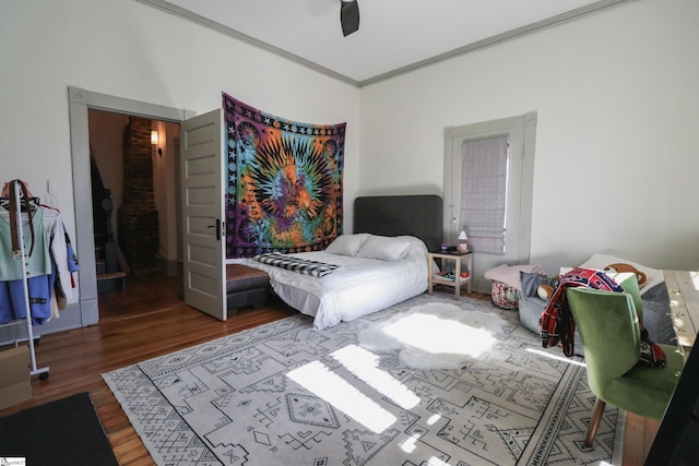 bedroom with ornamental molding, ceiling fan, and wood finished floors