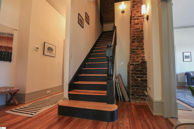 stairway with wood-type flooring and baseboards