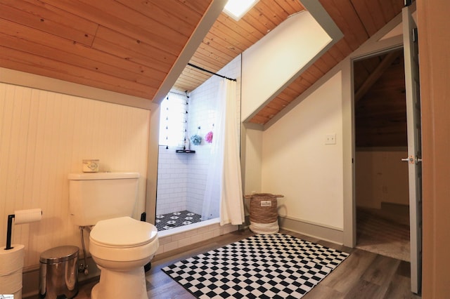 full bath with lofted ceiling, a shower stall, toilet, and wood finished floors