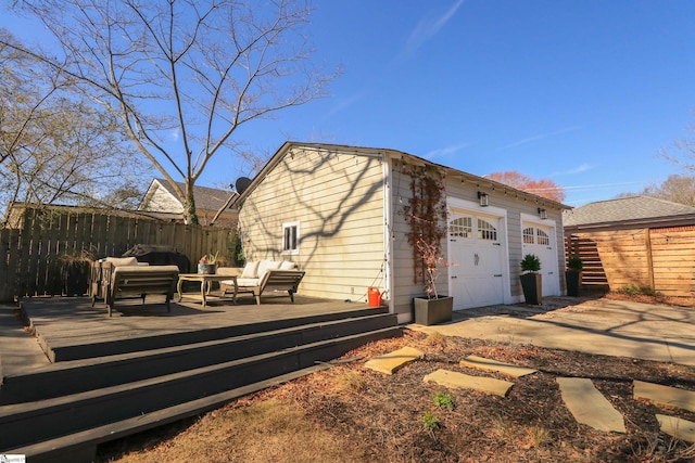 view of home's exterior featuring an outdoor hangout area, an outbuilding, a wooden deck, and fence