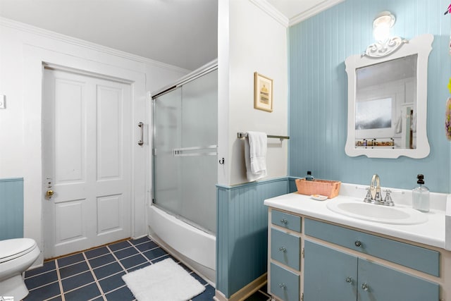 bathroom featuring toilet, ornamental molding, tile patterned flooring, combined bath / shower with glass door, and vanity