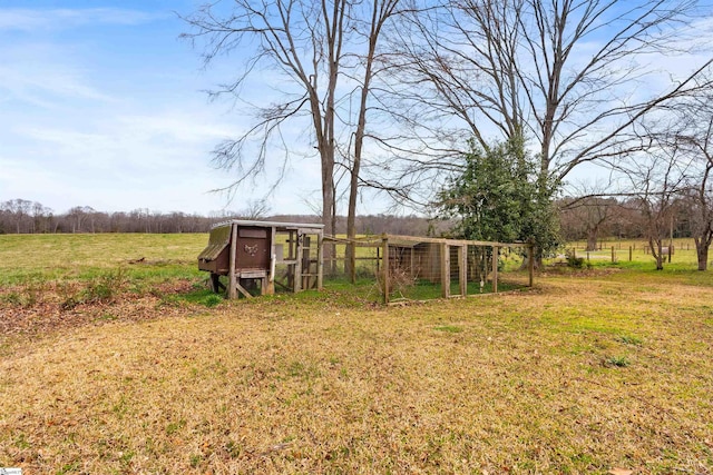 view of yard featuring an outbuilding, a rural view, and exterior structure