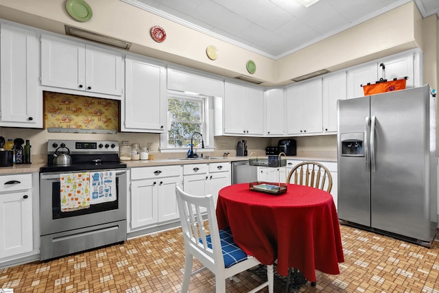 kitchen with a sink, white cabinetry, light countertops, appliances with stainless steel finishes, and crown molding