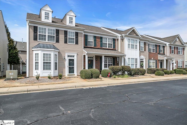 townhome / multi-family property featuring brick siding and cooling unit