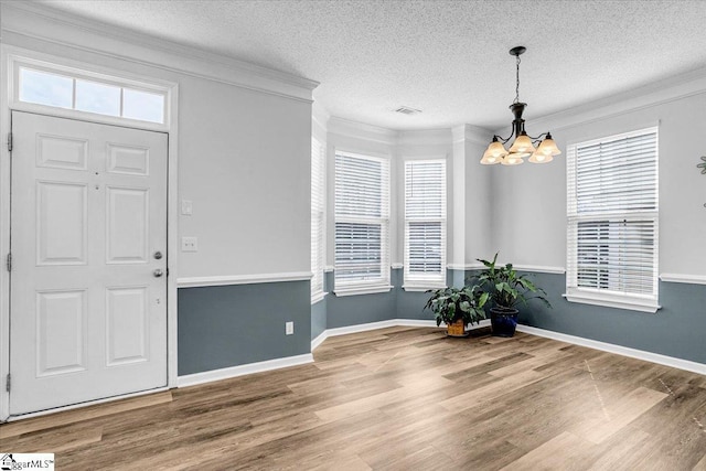 foyer entrance featuring ornamental molding, plenty of natural light, and wood finished floors