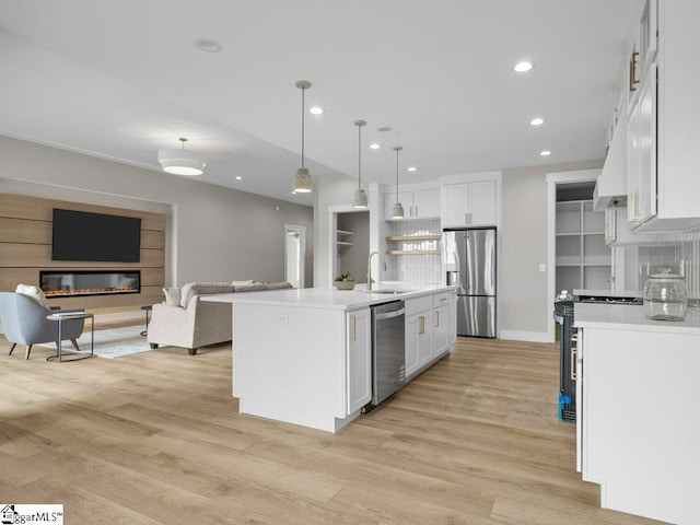 kitchen featuring open floor plan, light countertops, appliances with stainless steel finishes, and white cabinetry