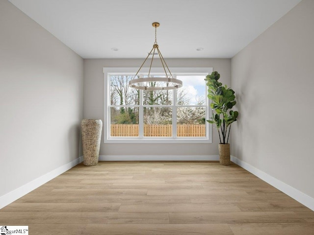 unfurnished dining area with a healthy amount of sunlight, baseboards, and wood finished floors