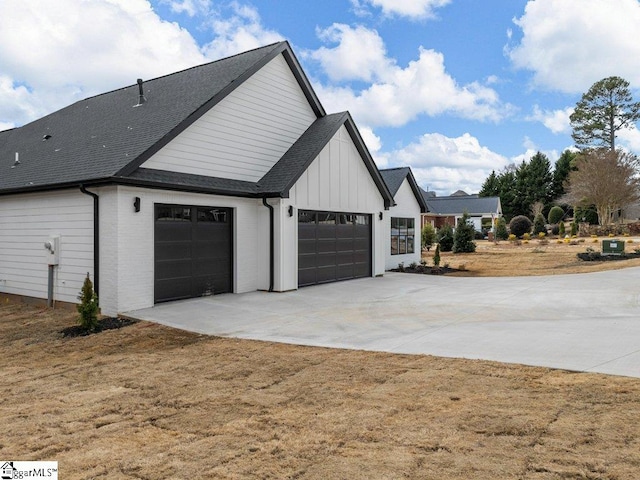 view of property exterior with driveway, board and batten siding, an attached garage, and roof with shingles