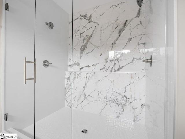 bathroom featuring a marble finish shower