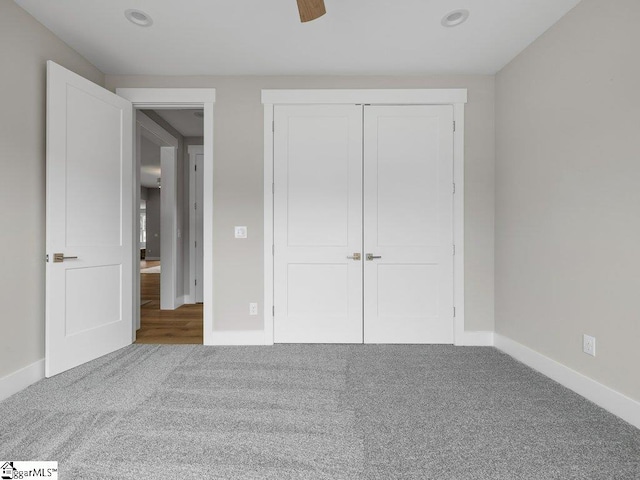 unfurnished bedroom with a ceiling fan, a closet, carpet flooring, and baseboards