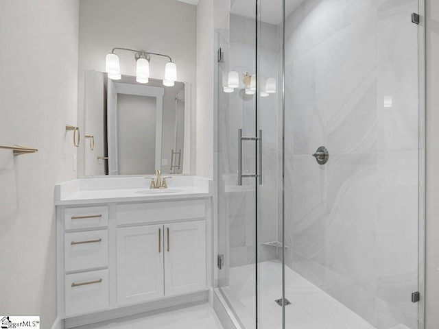 bathroom with a shower stall and vanity