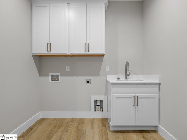 clothes washing area with washer hookup, a sink, baseboards, light wood-type flooring, and electric dryer hookup