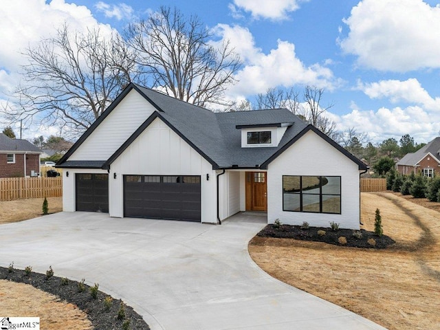 modern inspired farmhouse with a garage, a shingled roof, fence, driveway, and board and batten siding