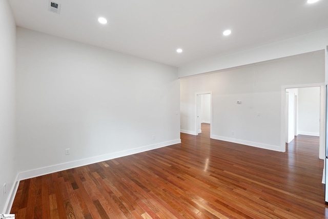 empty room featuring recessed lighting, visible vents, baseboards, and wood finished floors