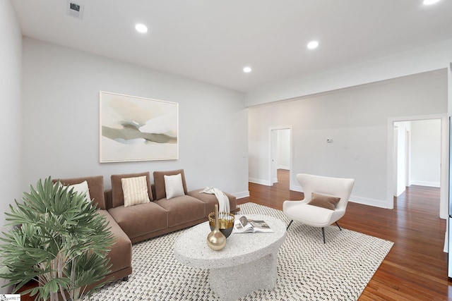 living area with baseboards, visible vents, wood finished floors, and recessed lighting