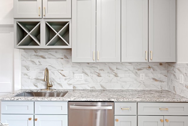 kitchen with decorative backsplash, dishwasher, light stone counters, and a sink