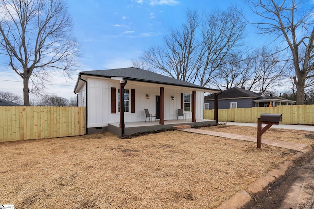 view of front of property featuring board and batten siding, crawl space, roof with shingles, and fence