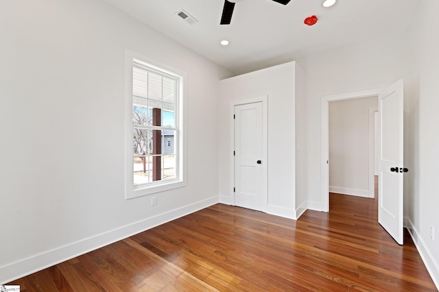 unfurnished bedroom featuring baseboards, visible vents, wood finished floors, and recessed lighting